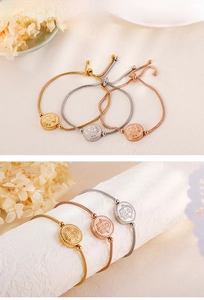 Macro view of adjustable stainless steel Hamsa Hand charm bracelets in gold and silver