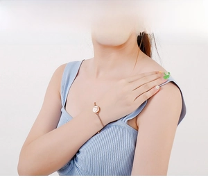 Rose gold adjustable chain bracelet with round palm charm shown on a female model