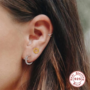 Detailed view of S925 sterling silver cross earring with crystal studs on ear