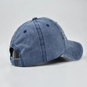 Macro view of blue washed cotton baseball cap featuring adjustable bronze metal buckle