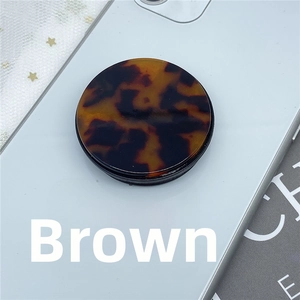 Close-up of brown tortoiseshell pattern folding phone grip on a smartphone back