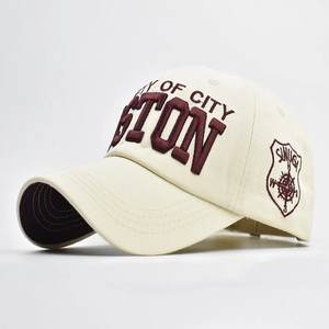 Detail of 3D embroidery and side shield patch on cream cotton baseball cap