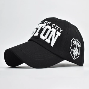 Detail of 3D embroidery and side compass patch on a black cotton baseball cap