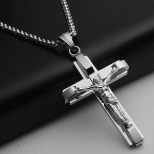 Detailed close-up of a polished stainless steel cross pendant and its matching link chain