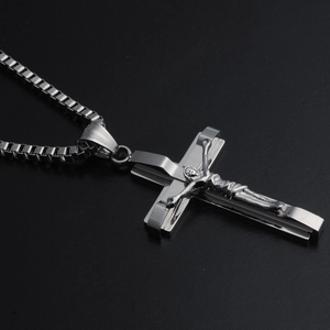 Detail of silver titanium steel cross pendant with crucifix on a sleek box chain necklace