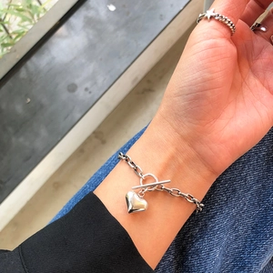 Close-up of 925 sterling silver heart charm bracelet with T-bar clasp and star ring