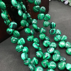Macro shot of green malachite teardrop beads with black stripes for jewelry making
