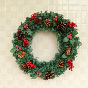 Christmas wreath with red berries and pine cones on a green needle base for home decor