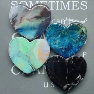 Detail of heart-shaped marble texture phone grips with high-gloss resin finish in four colors