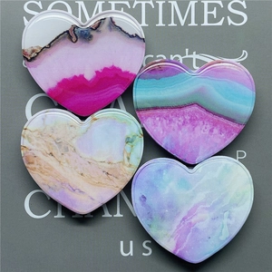 Close-up of heart-shaped marble resin phone grips with artistic fluid texture