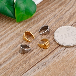 Gold and silver stainless steel ear cuffs shown with a coin for size reference