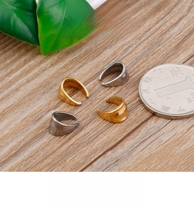 Detailed view of striped stainless steel clasp connectors on a wood surface with a coin