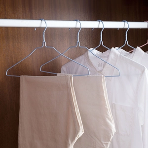 Light blue PVC coated metal clothes hangers for heavy duty drying in dark wood wardrobe