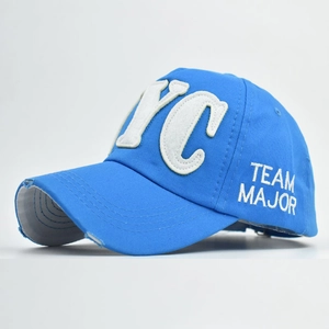Detail of NYC 3D embroidery and distressed ripped brim on a blue cotton baseball cap
