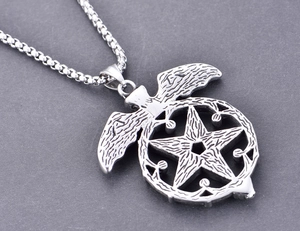 Macro d'un pendentif en acier titane argenté avec des motifs d'aigle et d'étoile