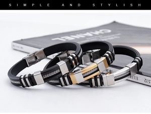 Detail of men's punk bracelet showing black silicone and gold stainless steel textures
