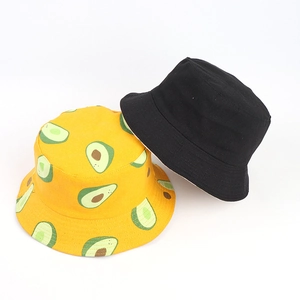 Détail de chapeaux bobs réversibles avec imprimé avocat jaune et toile noire minimaliste