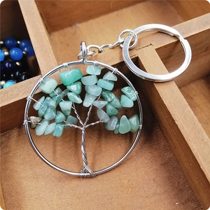 Macro detail of Tree of Life keychain featuring green crystal gravel and silver frame