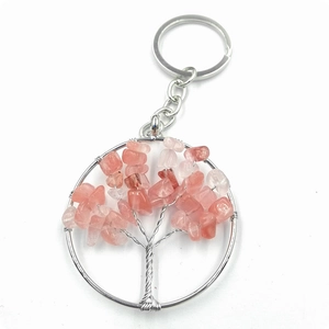 Macro detail of Tree of Life keychain featuring pink crystal gravel and silver wire wrap