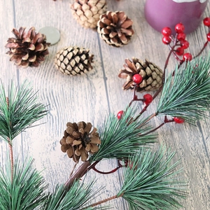 Natural pine cones with pine needles and red berries for Christmas DIY decor on wood