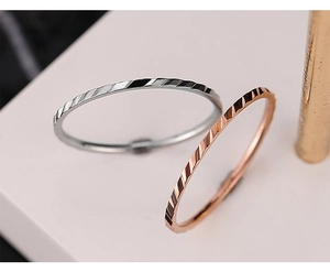 Dettaglio macro di anelli geometrici diamantati con finitura argento e oro rosa