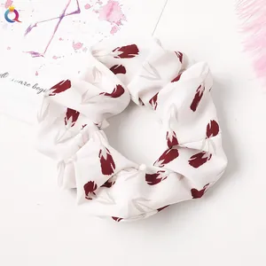 Detailed texture of white scrunchie with red tulip floral pattern on aesthetic background