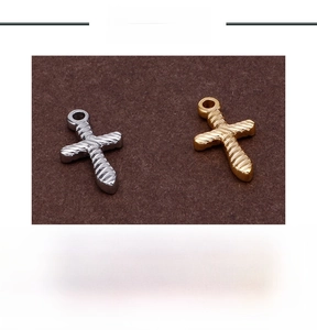 Close-up of titanium steel cross pendants in gold and silver with twisted texture