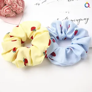 Detail shot of blue and yellow strawberry print scrunchies set with floral accents