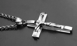 Detail shot of a silver crucifix pendant necklace in stainless steel with a metal chain