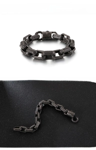 Close-up of vintage punk stainless steel chain bracelet with intricate floral engravings