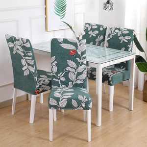 Dining room scene featuring four stretch chair covers with green leaf and ladybug prints