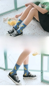 Close-up of vibrant blue cotton socks with yellow banana patterns and black canvas shoes