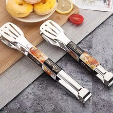Close-up of stainless steel food tongs for bread and pastry on a grey textured placemat
