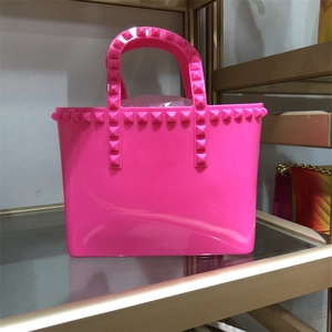Macro shot of pink PVC jelly bucket bag featuring golden pyramid stud rivet details