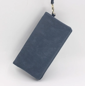 Detail of dark blue frosted long wallet with wristlet strap and gold metal hardware