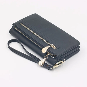 Close-up of black dual-zipper long wallet with golden water-drop pulls and wrist strap