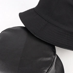Reversible black PU leather and cotton bucket hat showing premium fabric textures