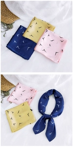 Close-up of bird print satin scarves in pink, yellow and navy with soft elegant texture