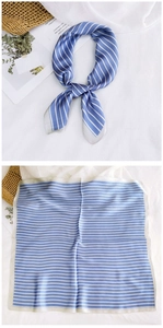 Close-up of blue and white striped silk scarf with elegant grey hemmed edges