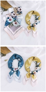 Detailed view of vintage floral silk scarves in ginger and teal with smooth silk texture
