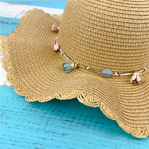 Women's woven straw sun hat with large wavy brim and colorful floral decoration