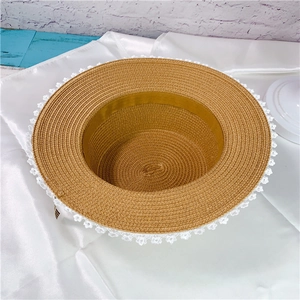 Flat top straw hat with white lace trim and bow accent in vintage pastoral style