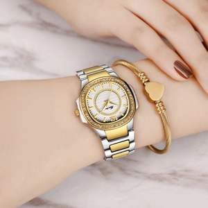 Detailed shot of a gold and silver stone-set women's watch with a heart bracelet