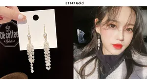 Close-up of elegant long tassel beaded earrings with white crystal beads and gold hooks