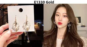 Detail view of long gold moon and star dangle earrings with crystal beads and tassel chain