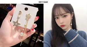 Detailed view of asymmetric star tassel earrings with faux pearls and gold plating