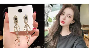 Golden tassel earrings with pearls and rhinestones shown on model and display card