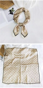 Detailed view of champagne silk scarf with white polka dots and contrast edge design