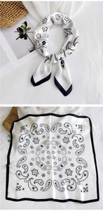 Detail view of square white silk scarf with black paisley print and border decoration