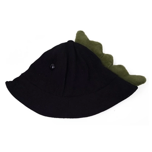 Détail du chapeau tricoté noir enfant avec écailles de dinosaure en peluche verte